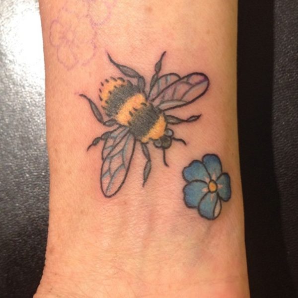 Bee And Small Blue Flower Tattoo On Wrist