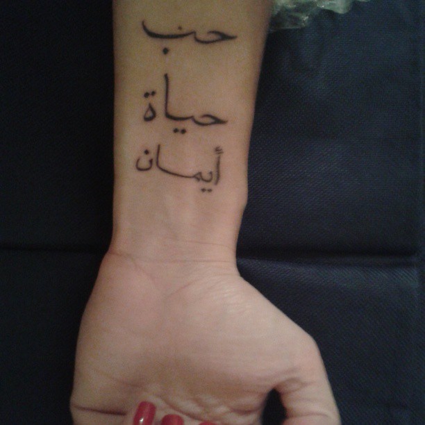 Black Inked Arabic Words Tattoo