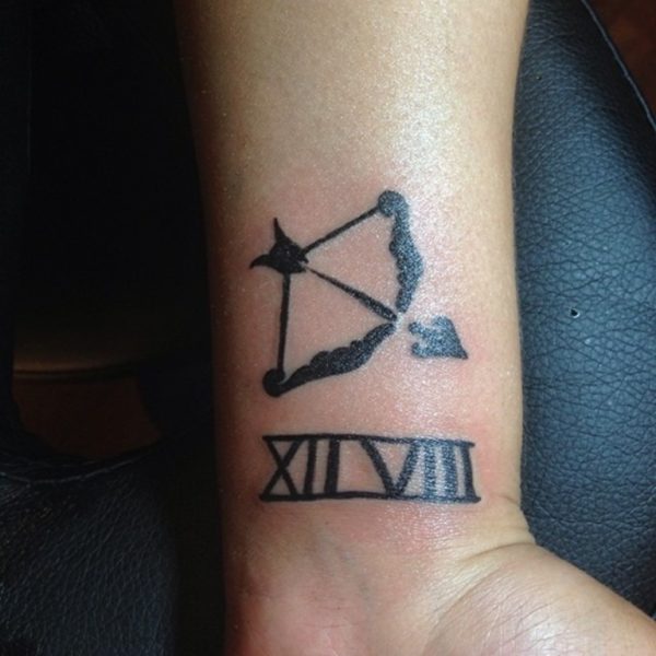 Bow Arrow With Numeric Tattoo On Wrist