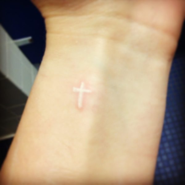 Small White Ink Cross Tattoo On Wrist