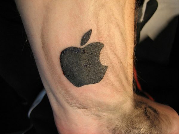 Black Ink Apple Logo Tattoo On Wrist