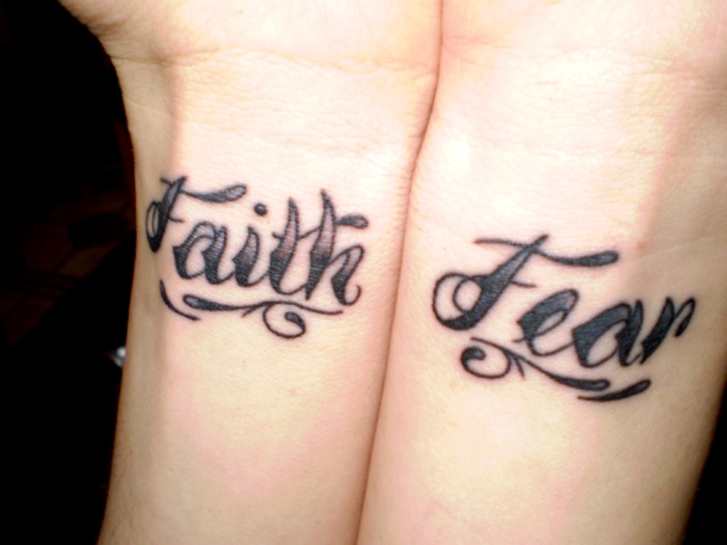 Faith And Fear Tattoo On Wrist.