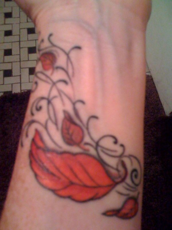 Orange Colored Leaf Tattoo On Wrist